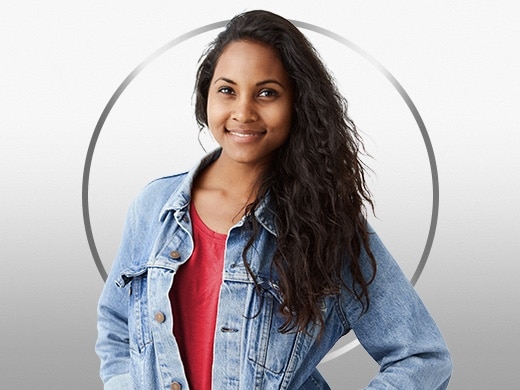 Smilende ung kvinde med mørkt hår i rød t-shirt og denimjakke, der er glad efter Canesten® behandling