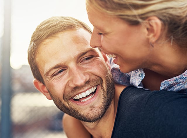 Smilende ungt par, der morer sig og er glade efter en Canesten® behandling